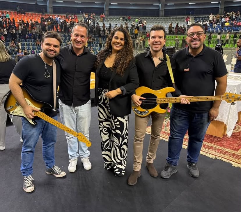 Samuel e músicos com seus baixos e guitarras em evento em ginásio