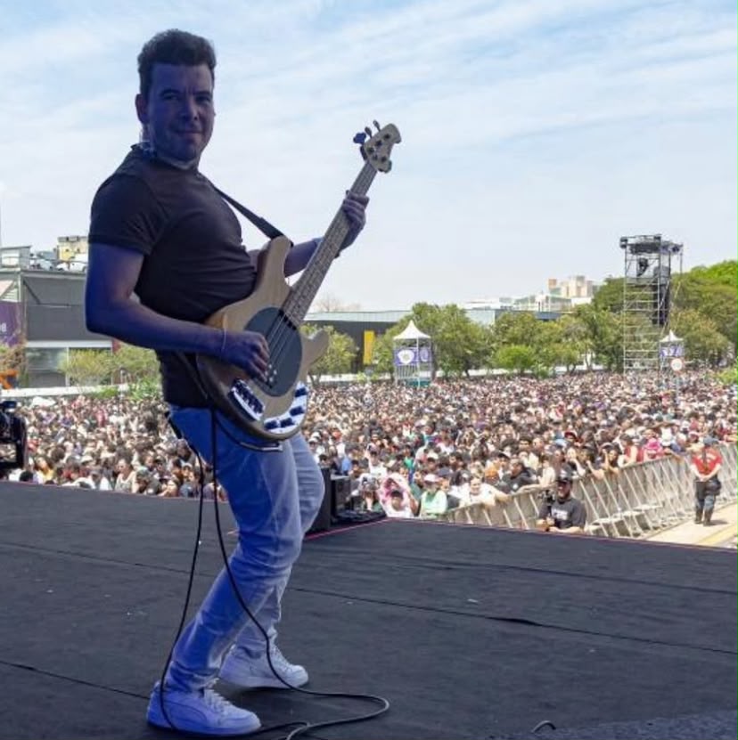 Samuel tocando baixo em festival ao ar livre