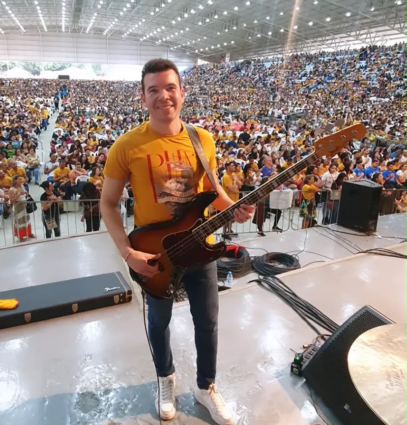 Samuel com seu baixo em evento em estádio cheio